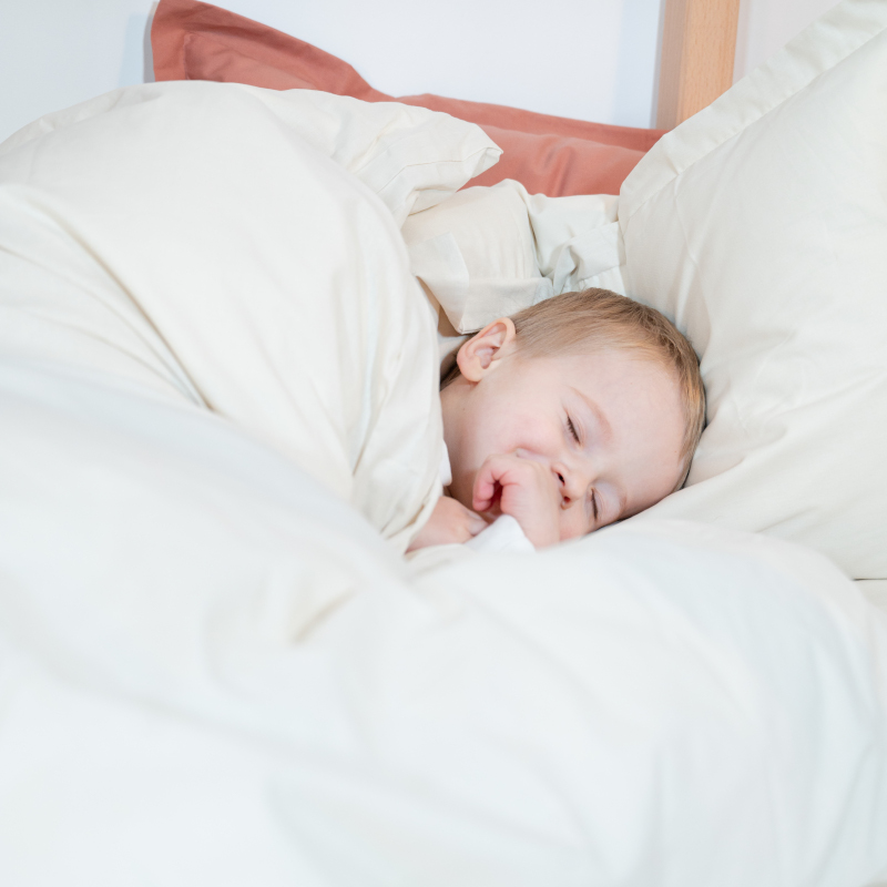 image représentant un enfant dormant paisiblement dans une couette Cosme