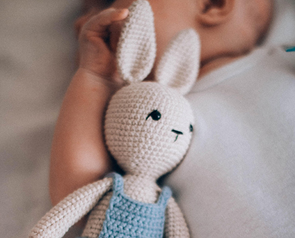 Bébé qui dort paisiblement sur son matelas latex naturel avec son doudou