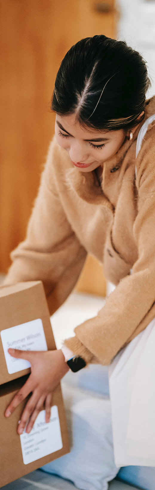 Femme ayant en mains des cartons livrés