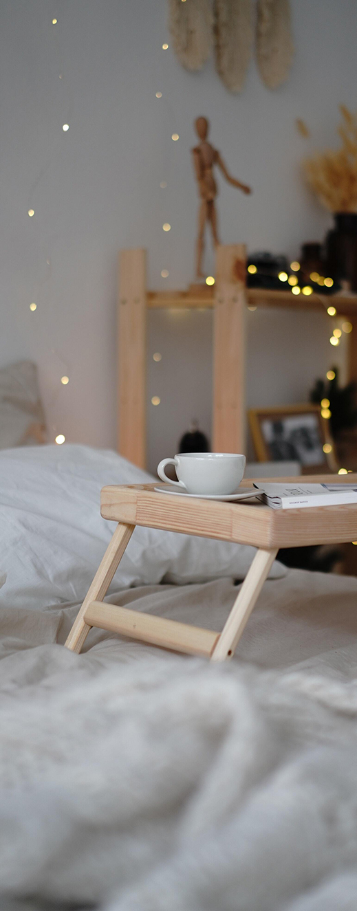 Café sur un plateau en bois beige posé sur un matelas fabriqué en France