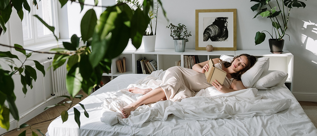 Femme allongée lisant un livre sur un matelas en latex naturel