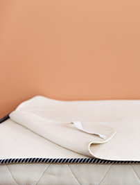 Alèse Le Petit Cosme, posée sur un matelas de la même marque gamme bébé