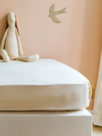 Linge de lit Le Petit Cosme, recouvrant un matelas posé sur un sommier