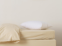 Oreiller et linge de lit installés sur un matelas enfant Le Petit Cosme