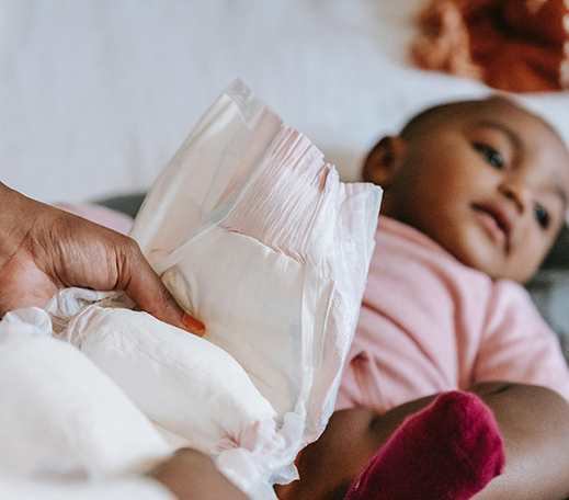 Femme qui tient dans sa main une couche pour changer son bébé