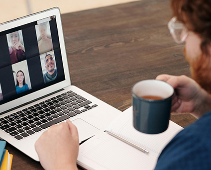 Papa en visioconférence avec une tasse de café à la main