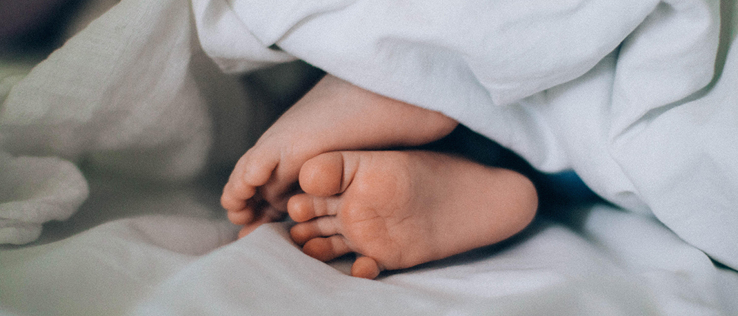 Pieds d’un bébé dépassant d’une couverture