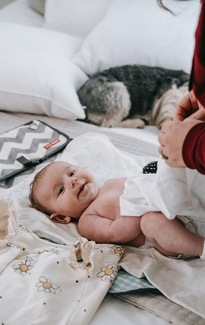 Femme qui habille son bébé pour la nuit