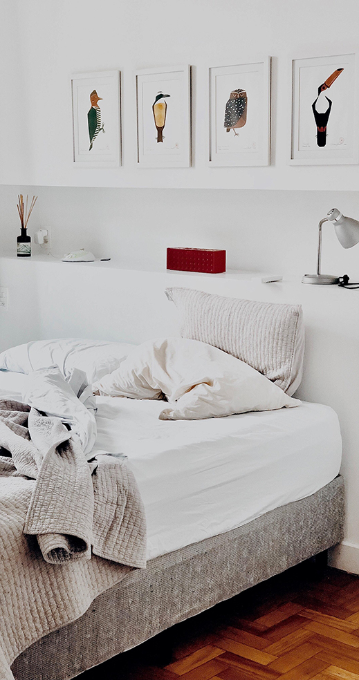 Draps défaits sur un matelas dense en latex naturel dans une chambre aux tons naturels