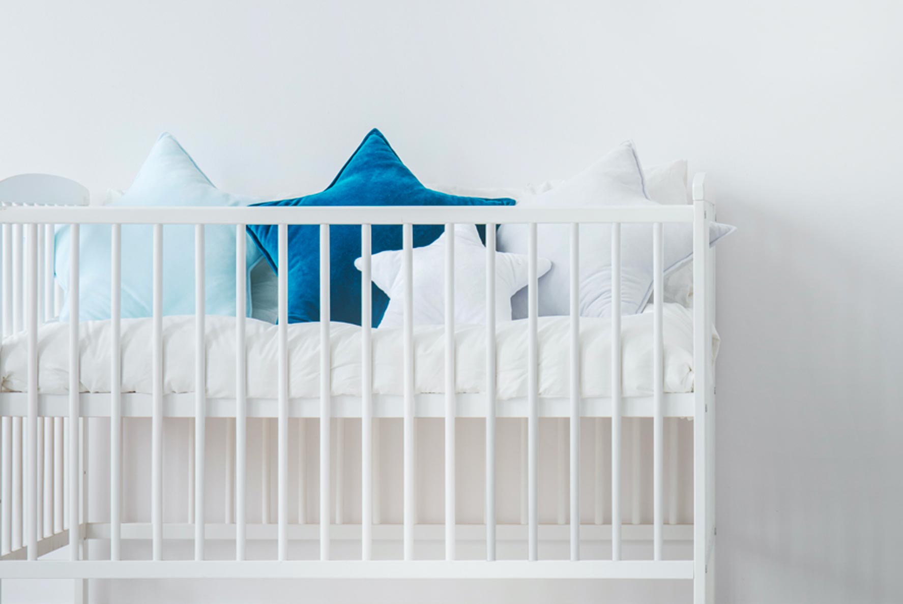 Matelas bébé Le Petit Cosme placé dans un lit à barreaux dans une chambre bébé