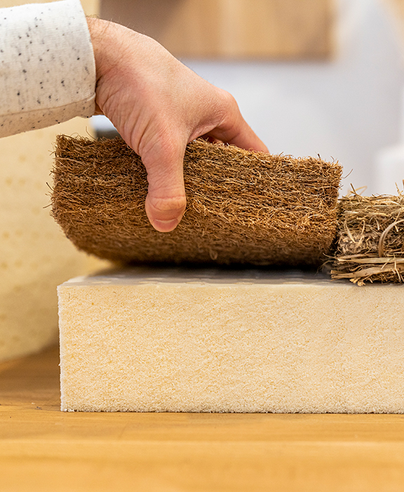 Main soulevant de la fibre de coco posée sur du latex naturel