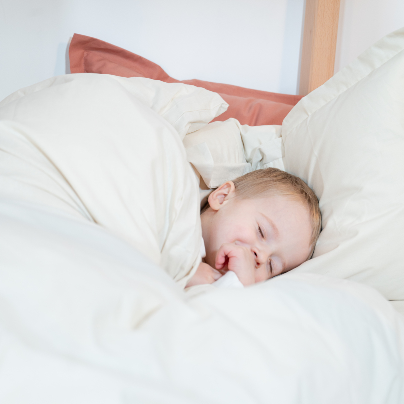 Image représentant un enfant dormant dans un lit avec un oreillé enfant LPC