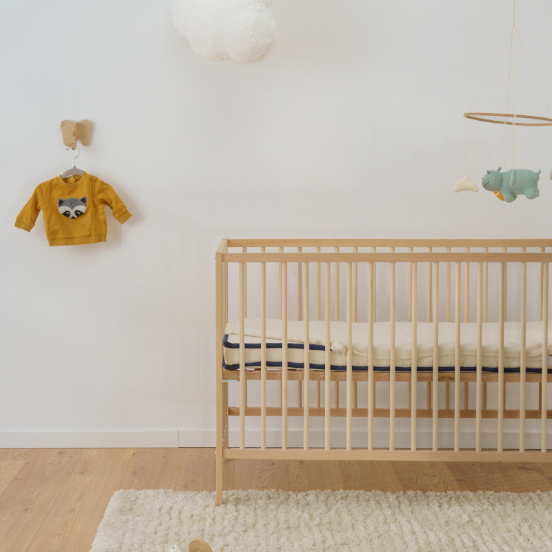 image représentant un enfant dormant dans un lit composé d'une parure de lit en coton bio gris