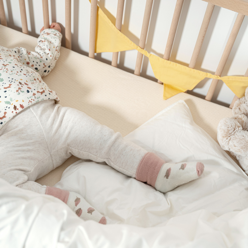 image représentant un enfant dormant dans un lit à barreau