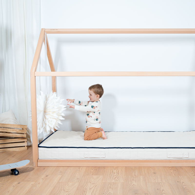 Image représentant un enfant jouant dedans le lit cabane Cosme