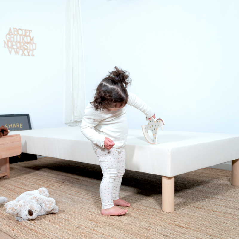 image représentant un sommier tapissier enfant Cosme avec un enfant jouant dessus