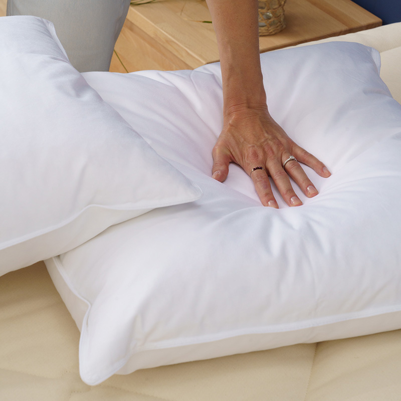 Main pressant l'oreiller duvet ferme Cosme