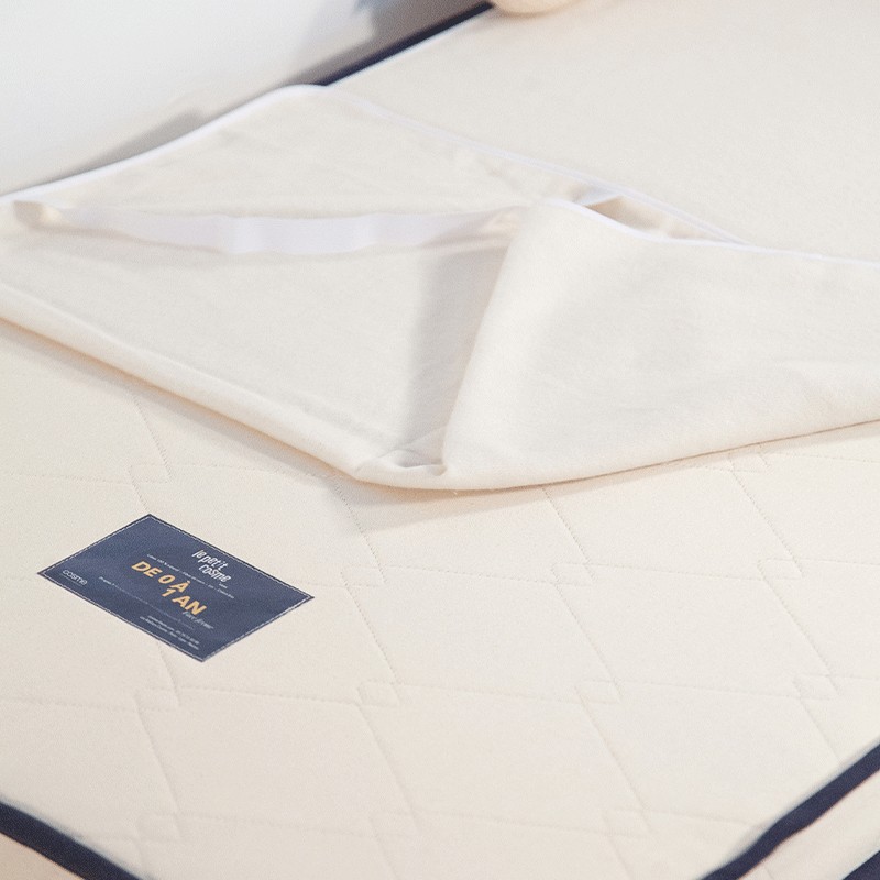 Gros plan sur la texture douce d'une alèse en coton bio sans traitement chimique.