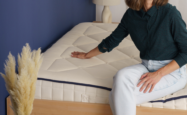 Image réprésentant une femme posant sa main sur un matelas en latex naturel