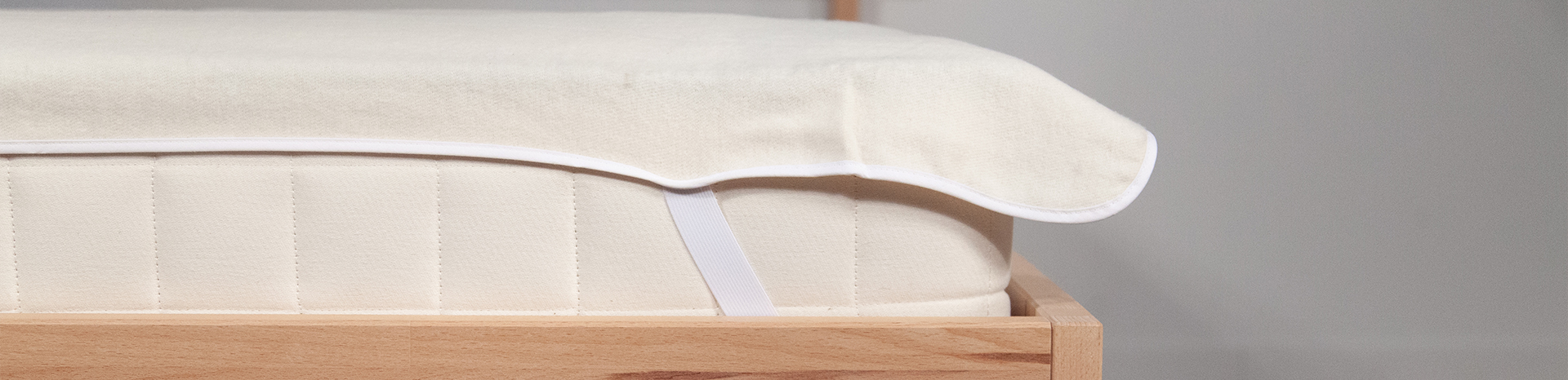 Le protège-matelas en coton bio Cosme installé sur le coin d'un matelas.