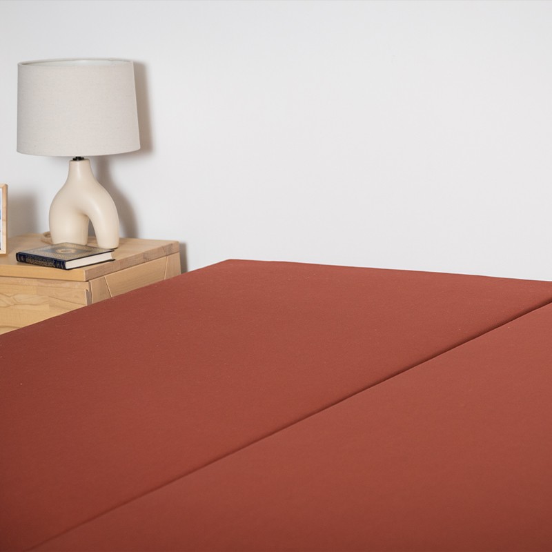 Détail de la structure recouverte de tissu d'un sommier tapissier.