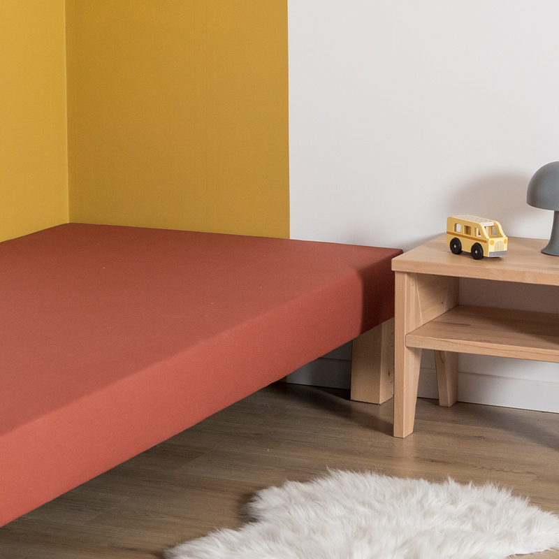 image représentant un sommier tapissier Le Petit Cosme terracotta avec un zoom sur le tissus