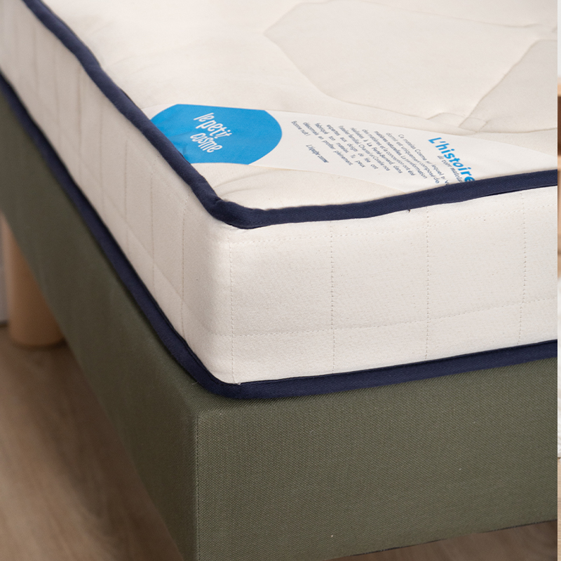 image représentant un zoom sur un matelas Le Petit Cosme posé sur un sommier vert bouteille